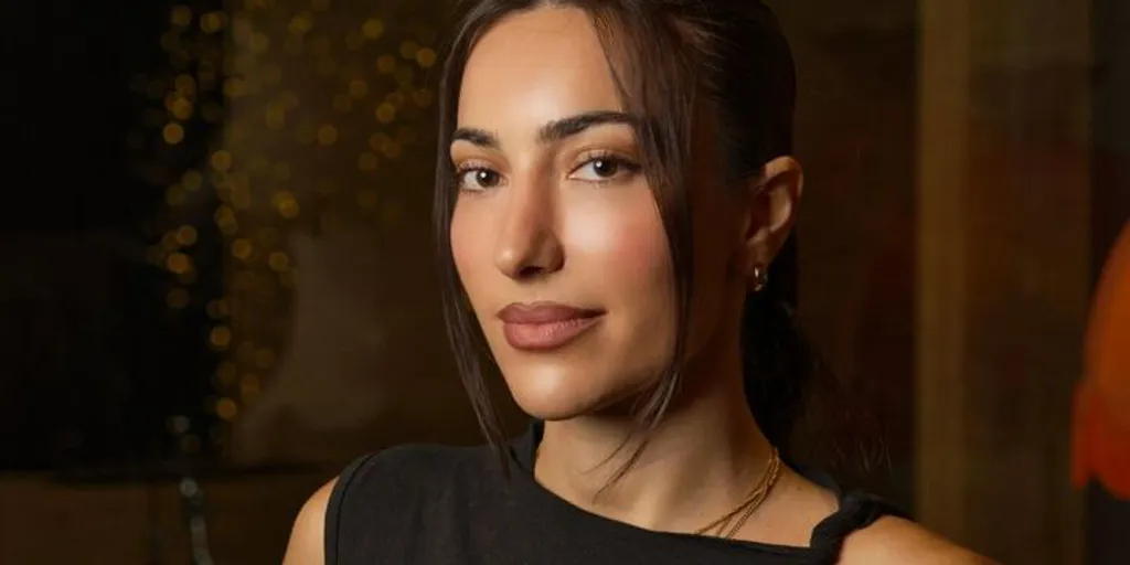 NOURI stands facing the camera wearing a black singlet top