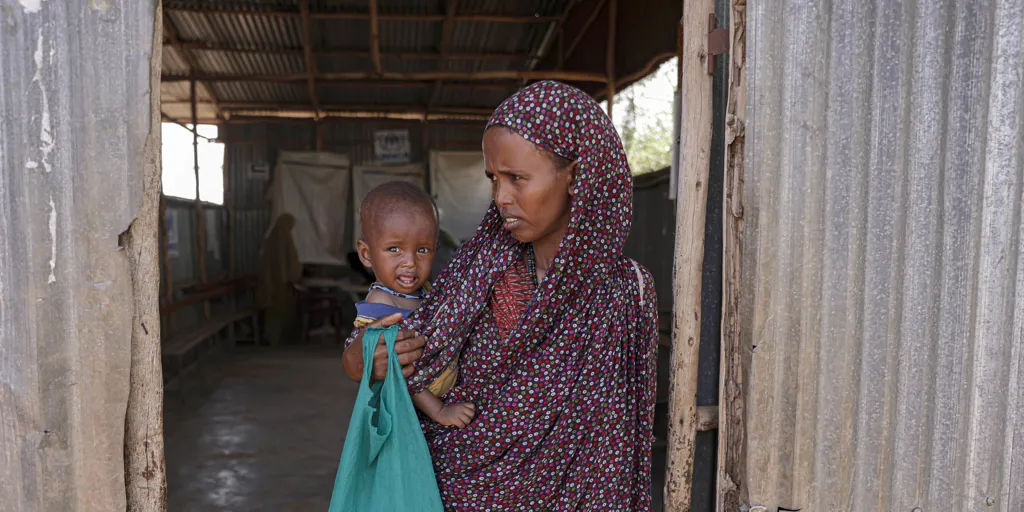 Samira Abdi, 28 waits to receive food and treatment for her malnourished child at the Melkadida UNHCR supported food distribution centre in Melkadida