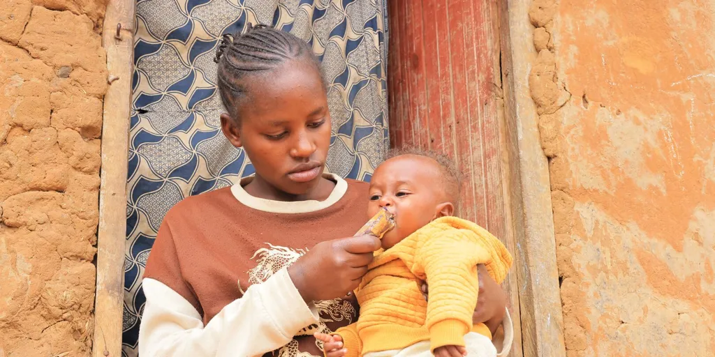 Kabanyana Sarah, a 22-year-old Rwandese refugee from Nyarugugu B in Nakivale Refugee Settlement, feeds her three-month-old son, Prince, with Ready-to-Use Therapeutic Food (RUTF).
